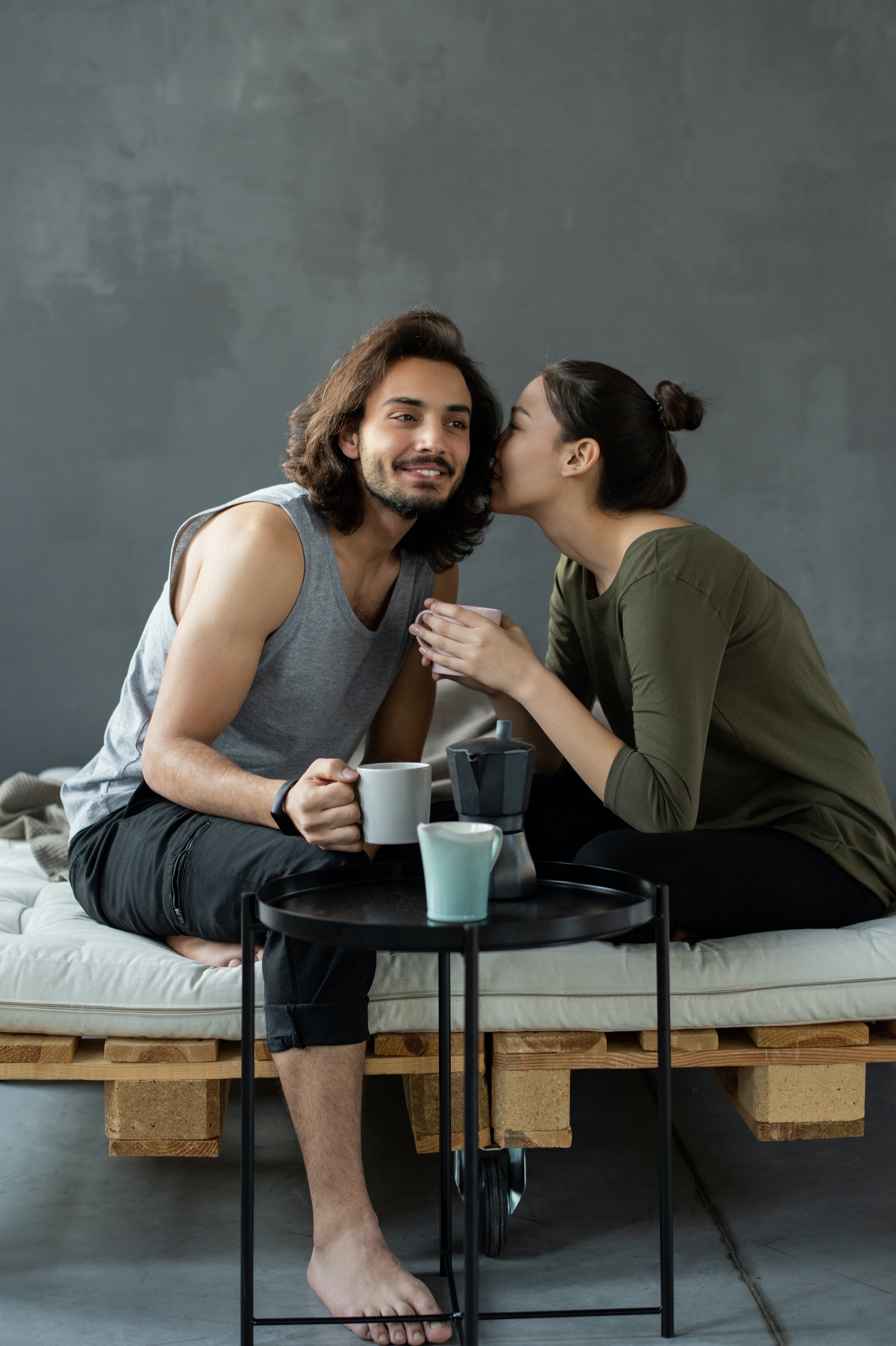 a woman whispering into a man's ear